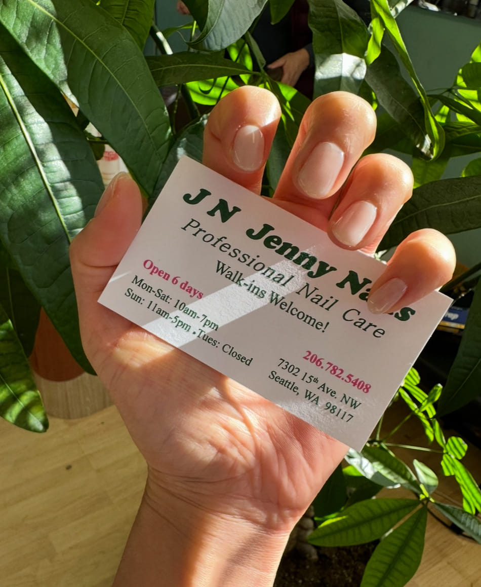 A customer holding the Jenny Nails business card: professional nail care, walk-ins welcome