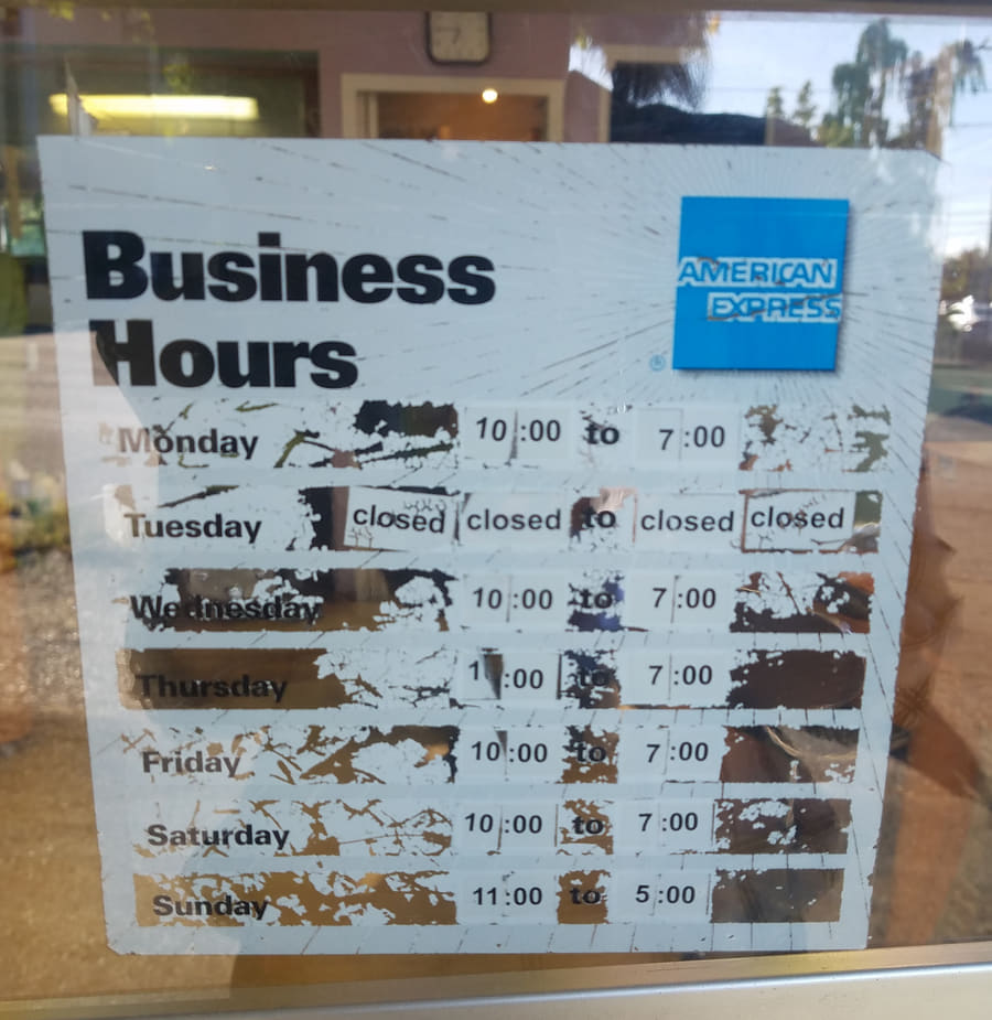 The hours decal on the shop door: Monday to Saturday 10 to 7, Tuesday closed, Sunday 11 to 5