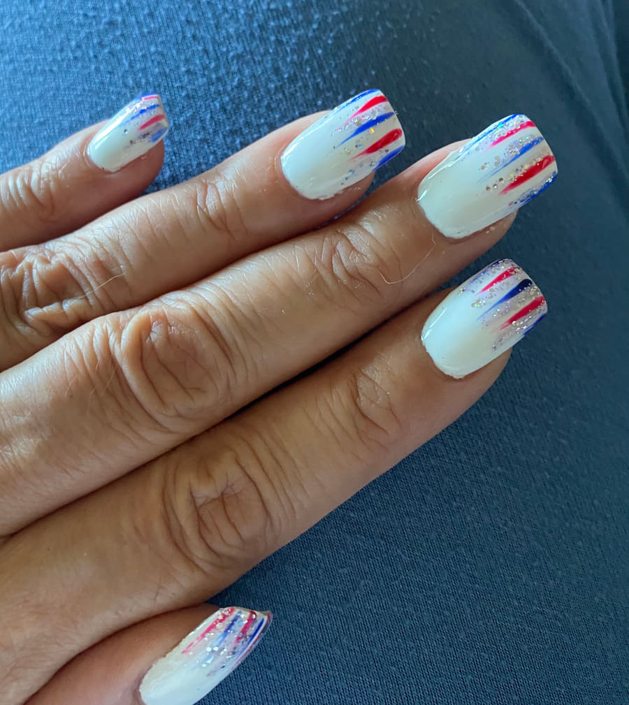 Long squared nails with fine red and blue streaks and silver glitter